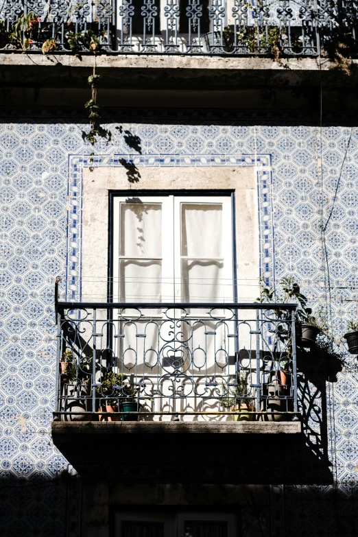 the balcony of an apartment building with bicycle and potted plants