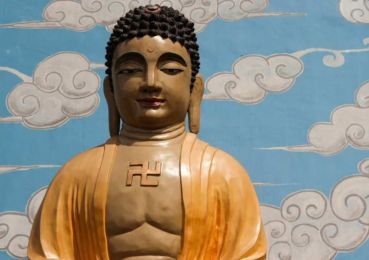 a big statue is near a blue sky with clouds