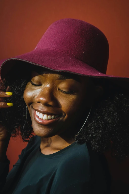 a young black woman wearing a purple hat