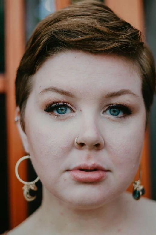 an attractive woman with big blue eyes in front of doors