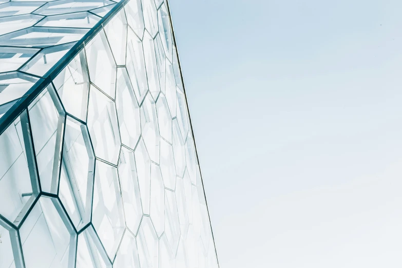 an airplane flying past a building with glass windows