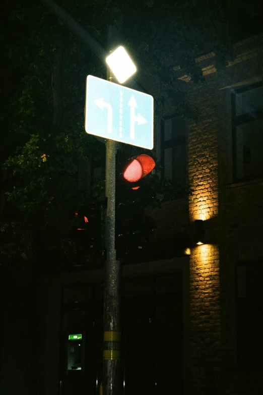 a lit up street sign and stop light in front of a building