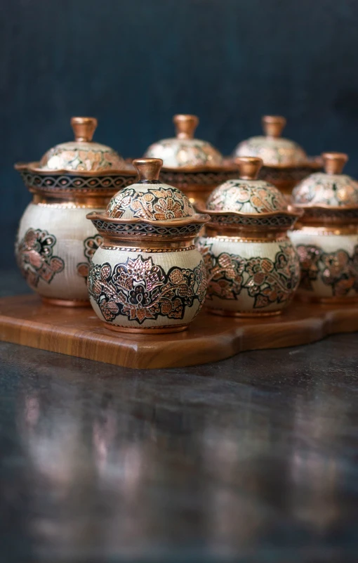 seven pieces of pottery on a wooden tray