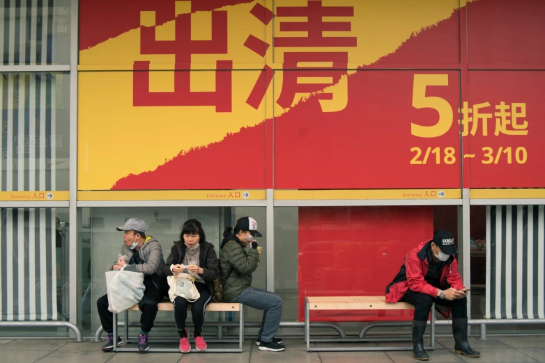 some people sitting on a bench near some buildings