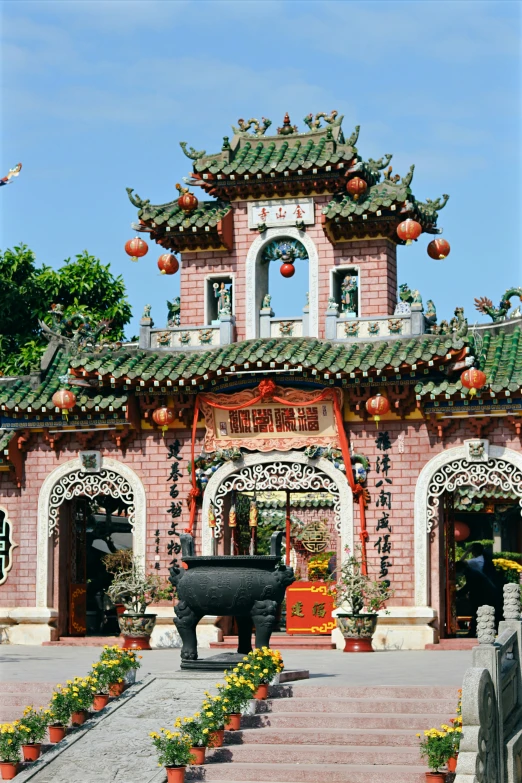 an old style chinese building with a clock tower and a big statue