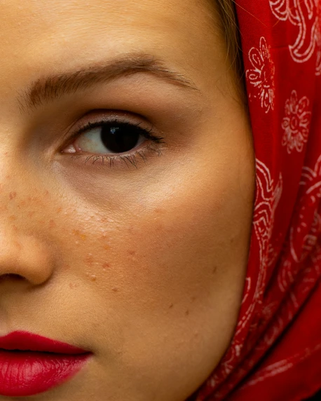 an oriental woman is wearing a red head covering