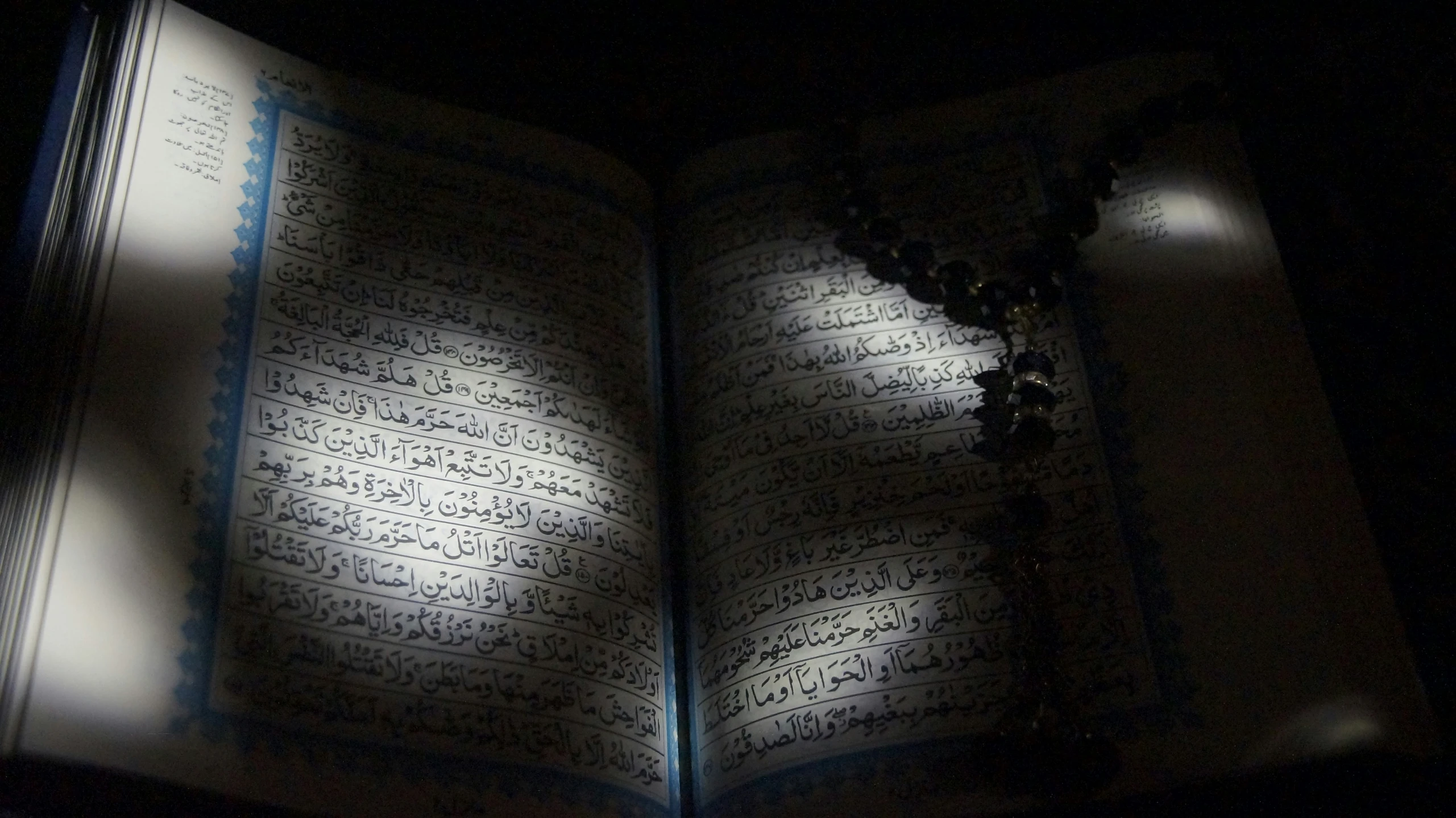 an open book with the pages illuminated by light from the darkness