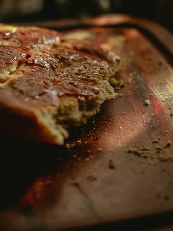 a piece of bread sitting on top of a wooden  board