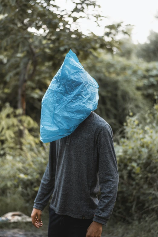 a man wearing a large blue bag over his head