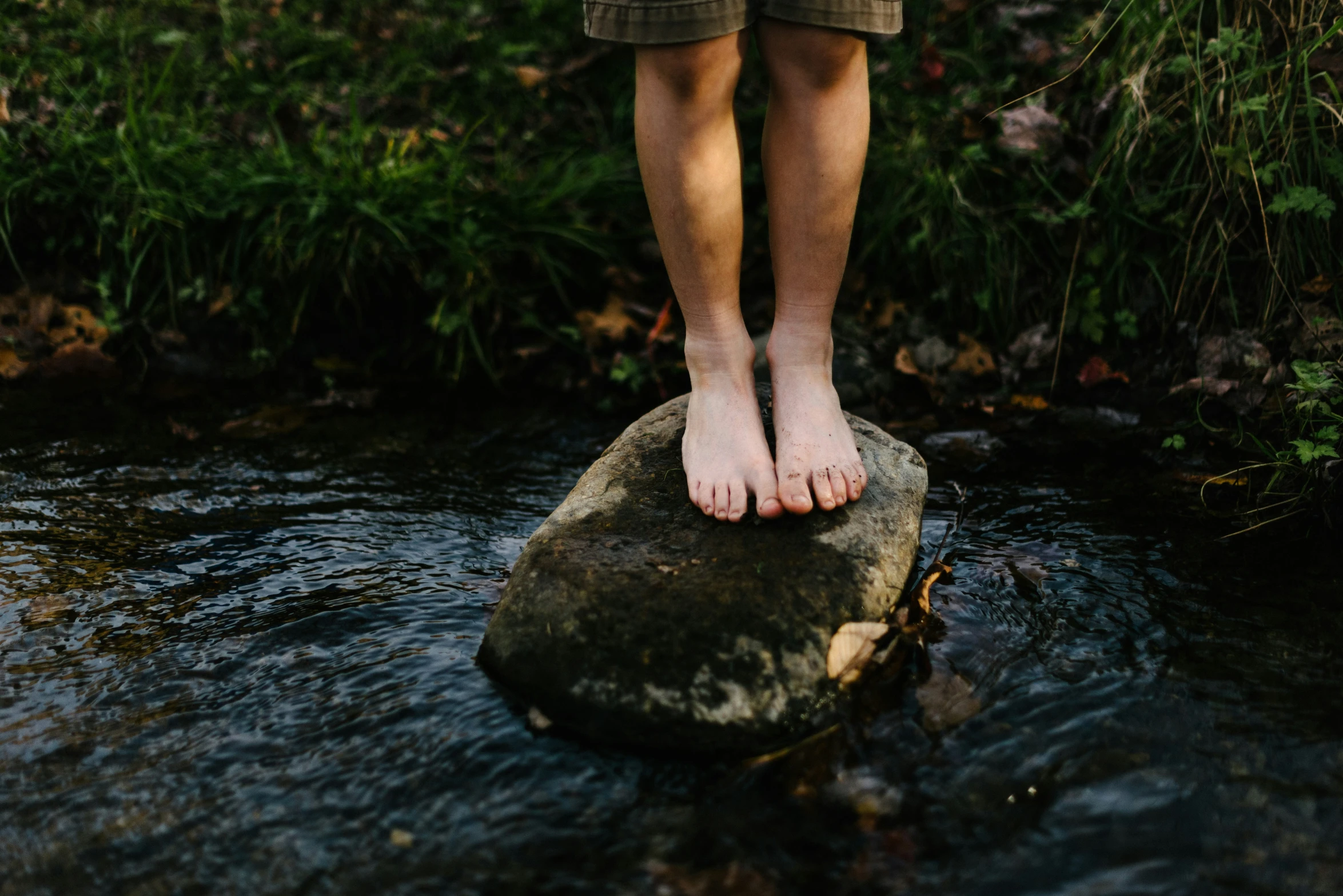 feet standing on a rock in the water