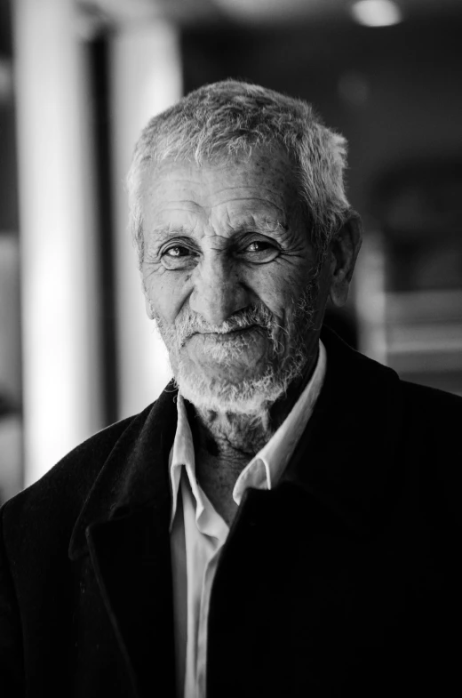 an older man with white hair in a black jacket