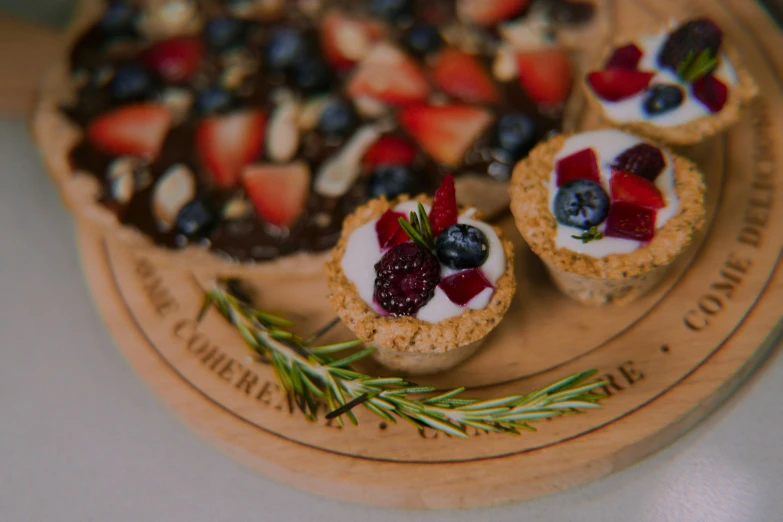 small snacks with berries, cream, and other toppings on a serving board