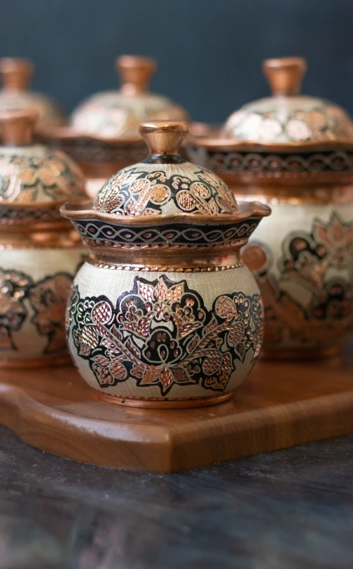 small round jars are adorned with decorative designs