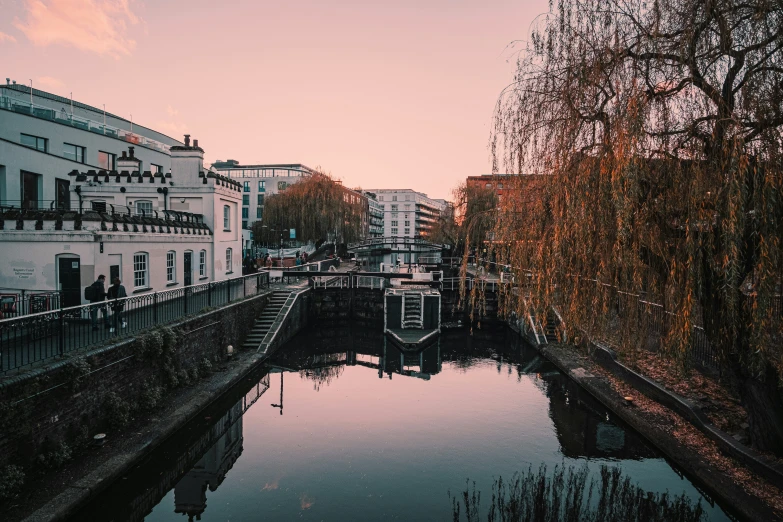 a river running between some buildings with a boat passing by