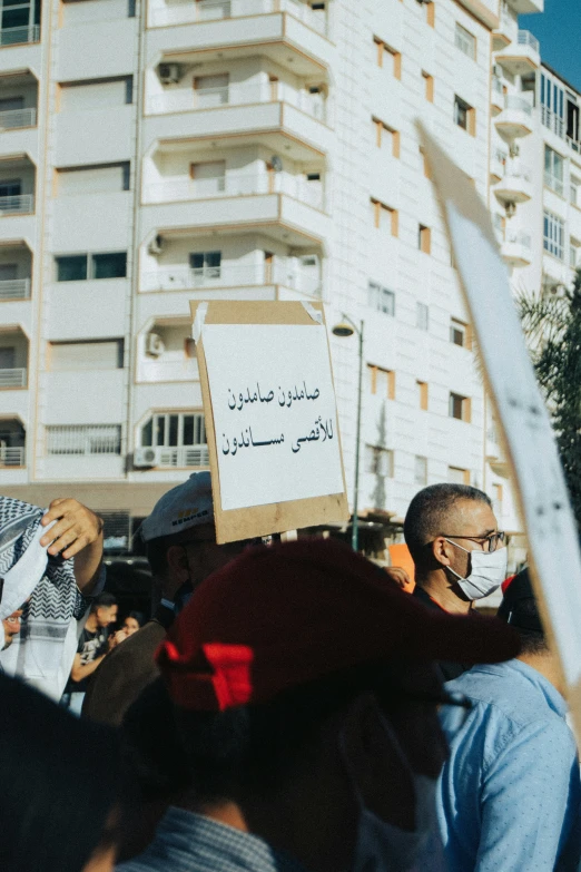 people holding up protest signs and wearing face masks