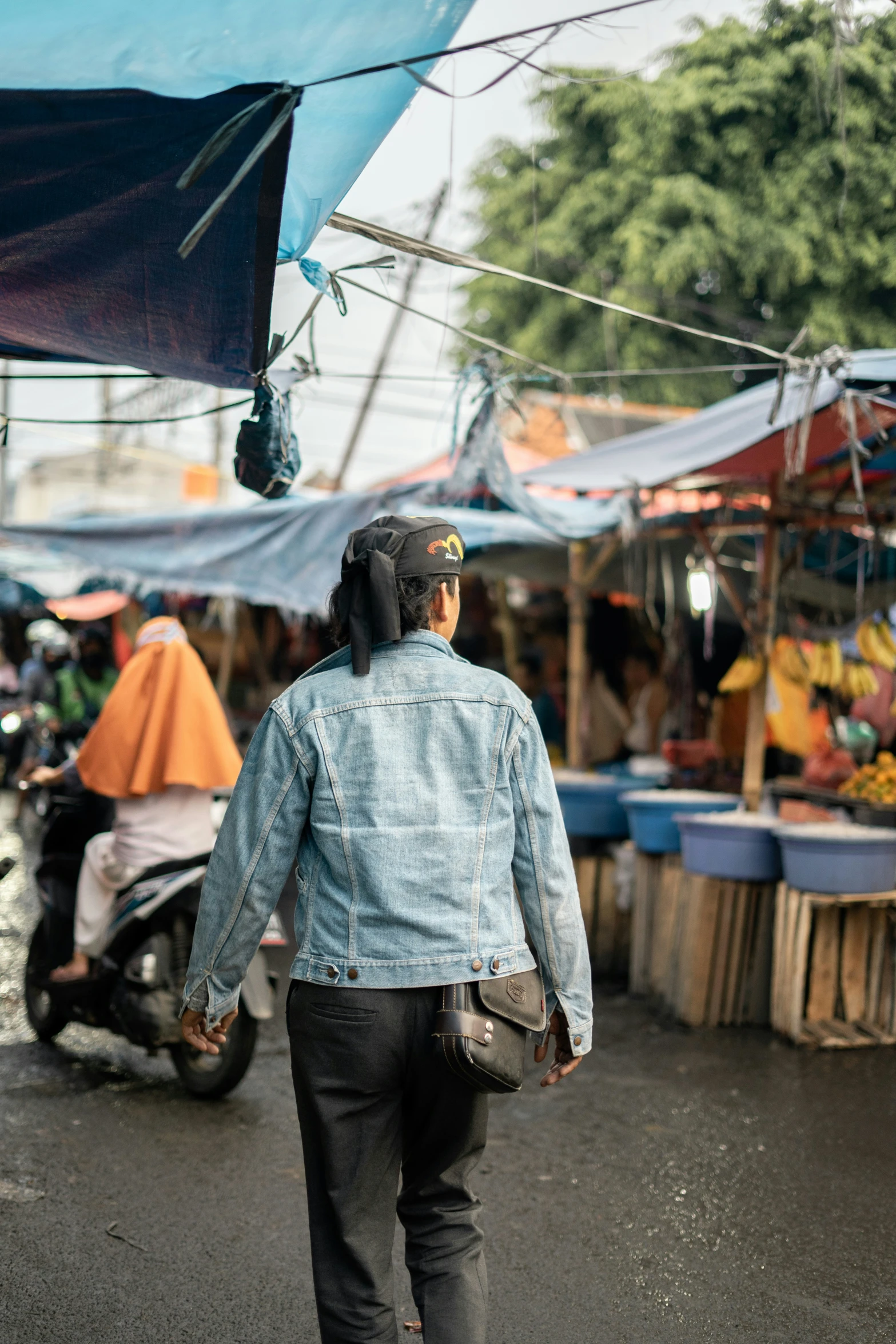 the person with a motorcycle helmet walks down a wet street