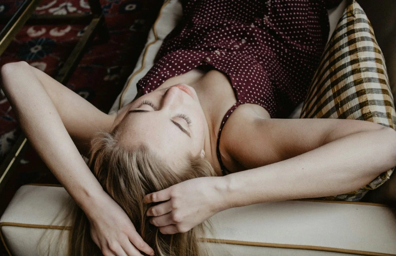 a woman laying on a bed next to blankets