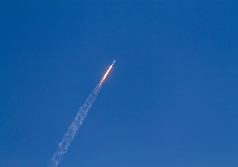 an airplane contrail flying overhead on a clear day