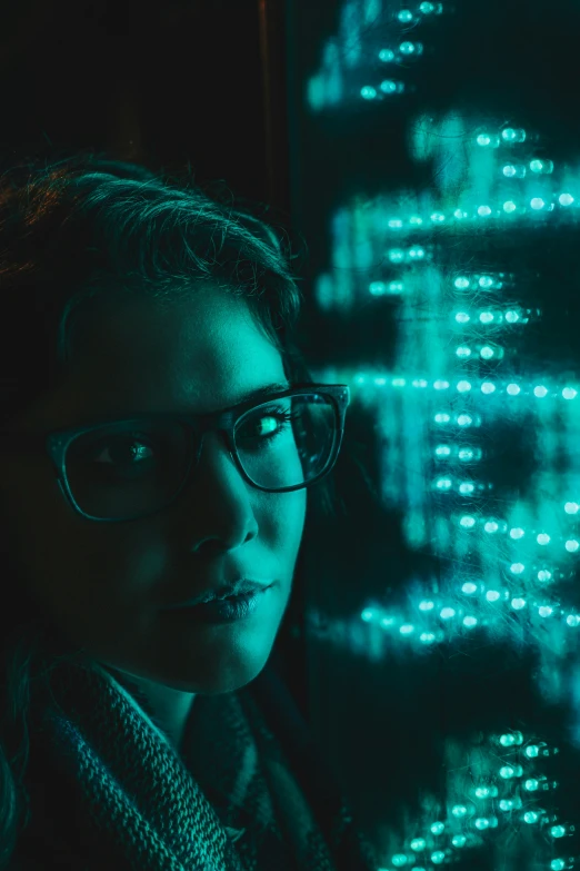 a woman wearing glasses standing in front of a window