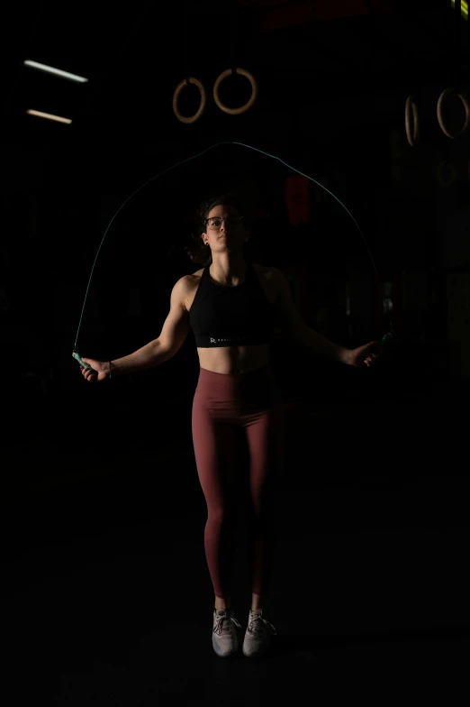 a woman holding a hoop in the dark