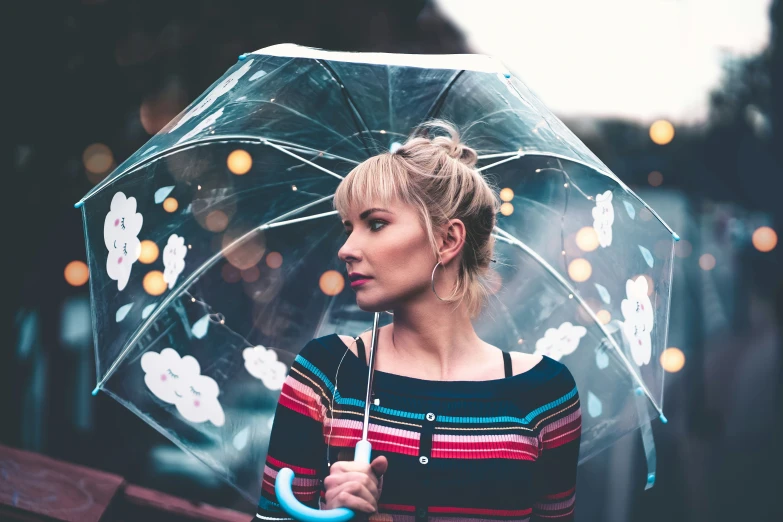 a woman standing underneath a clear umbrella and holding an umbrella