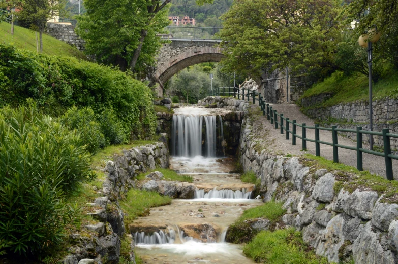 a waterfall flowing into a river with trees and rocks