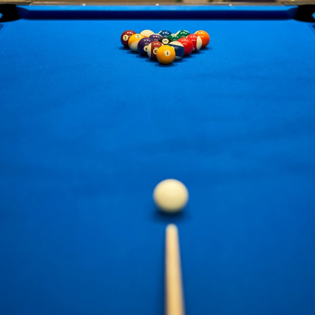 a pool table with eight balles and a cue