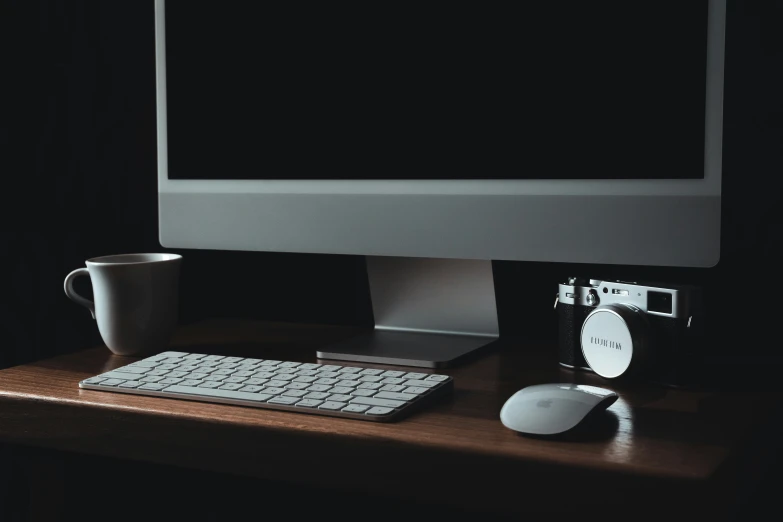 a computer monitor, keyboard and mouse on a desk