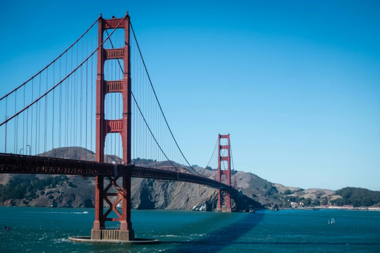 a large long bridge across the ocean from a city