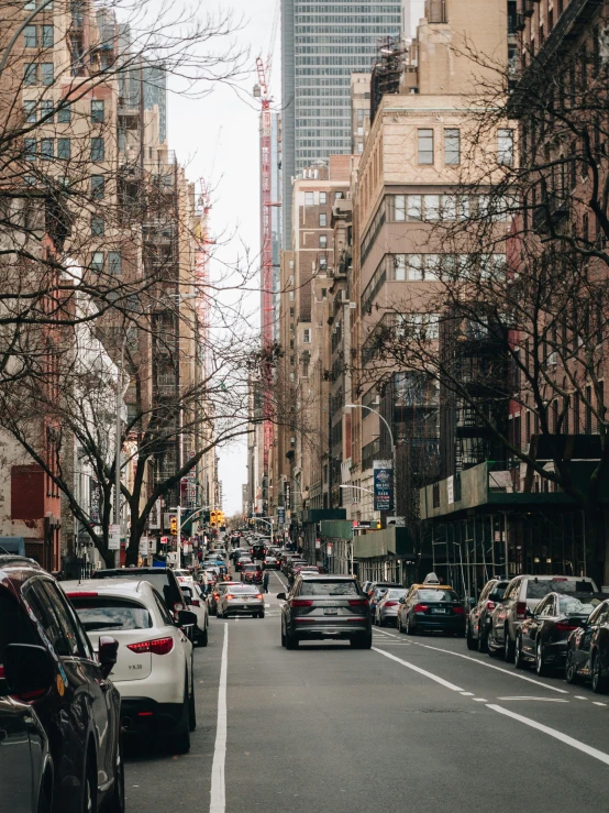 city street filled with cars next to tall buildings