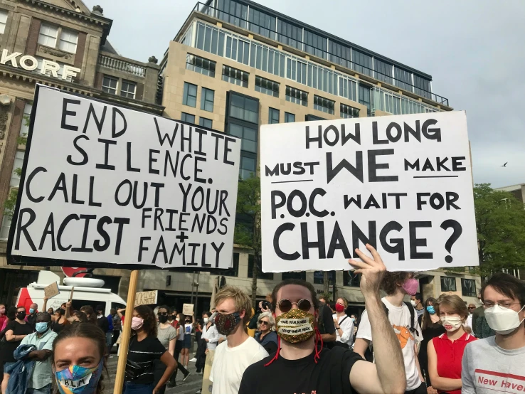 many people are marching and holding signs in protest