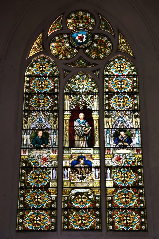 an ornate stained glass window with two figures in front of it