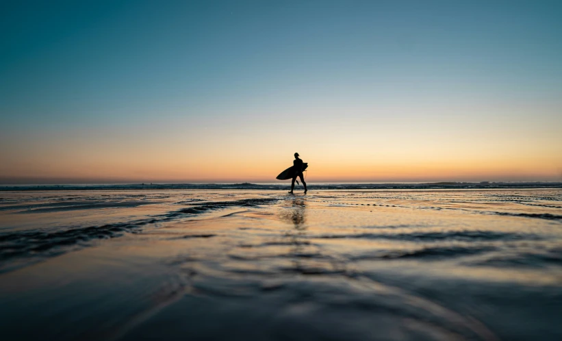 a person walking in the water with a surfboard