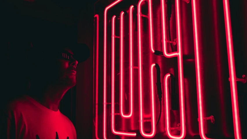 a man standing next to a neon display case