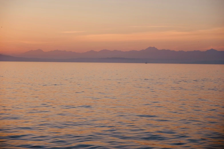 a man in silhouette fishing on the water during sunset