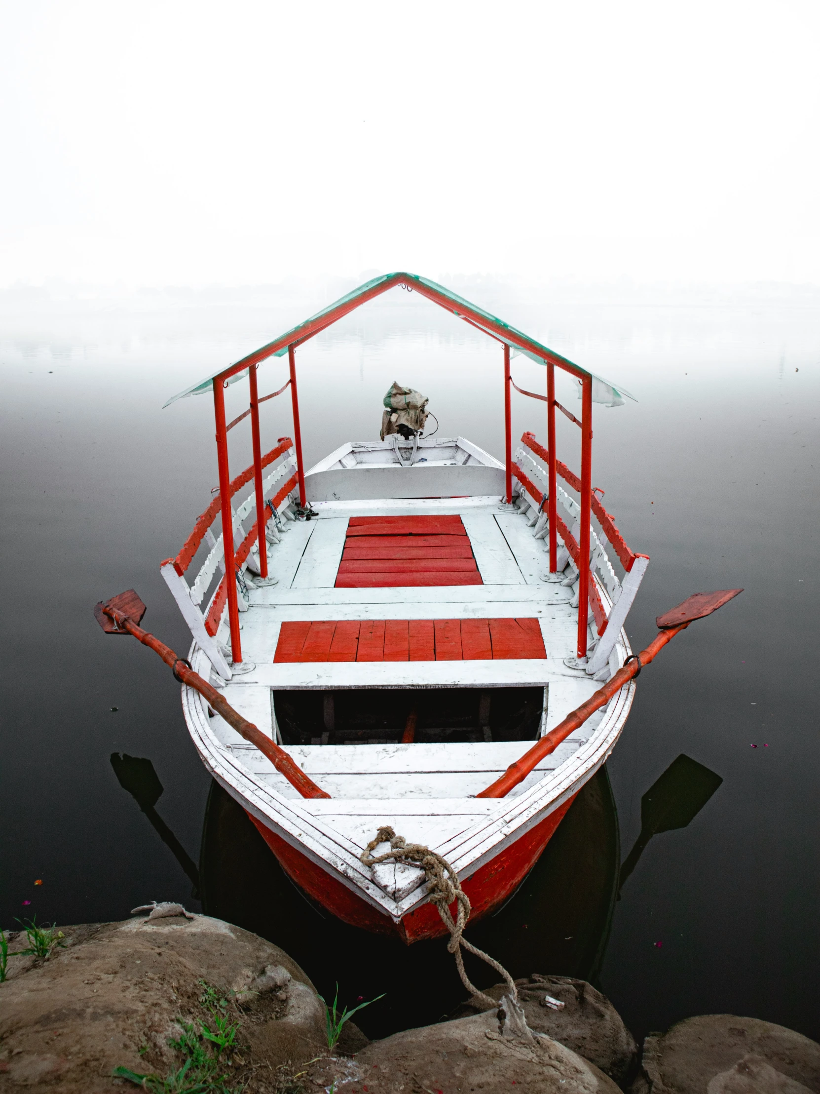 a boat sits docked on the side of a body of water