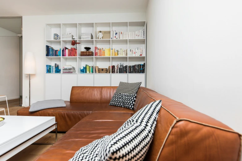 a leather sofa sitting in a living room next to a white table