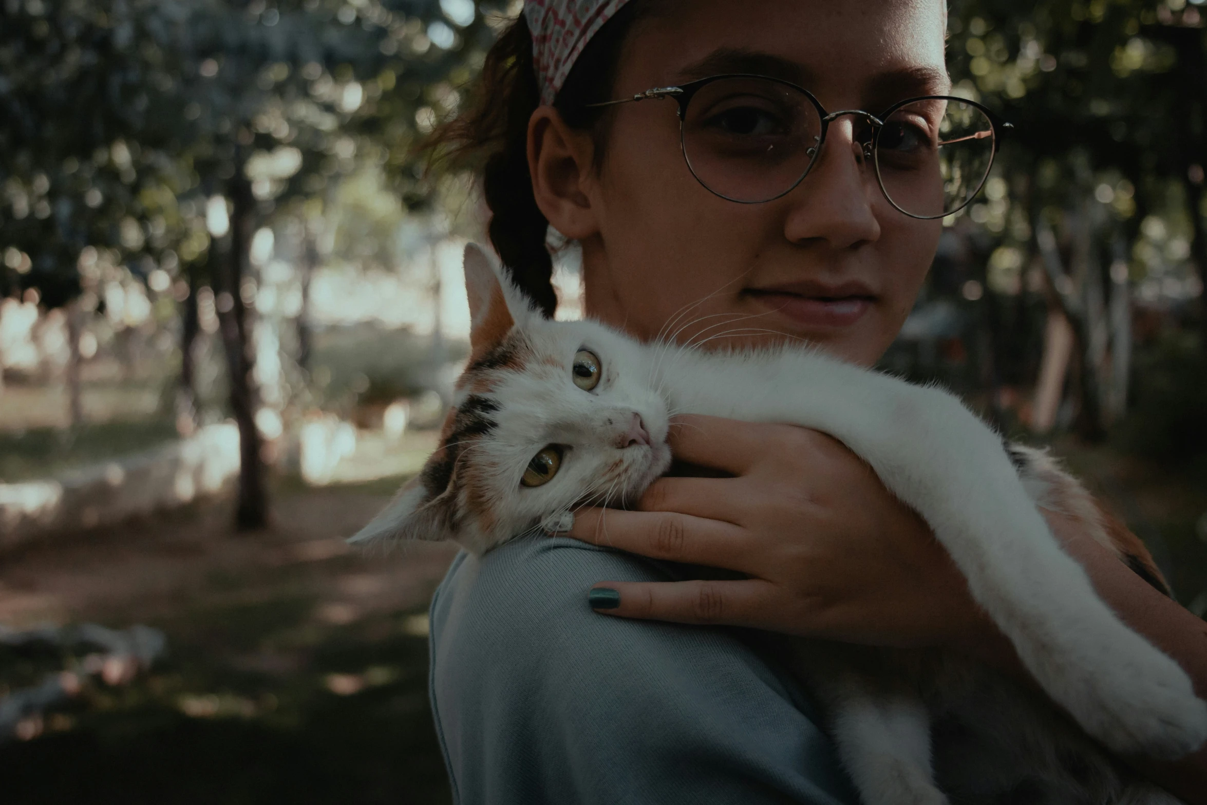 a woman holding a cat in her arms in the park