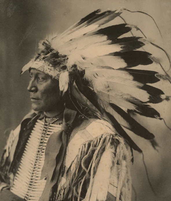 a old po of an indian man wearing head dress