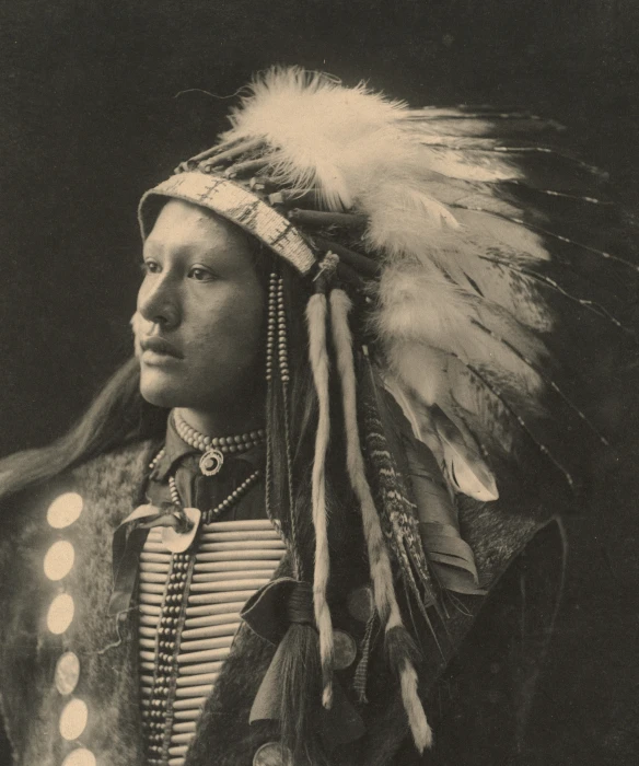 an old pograph of a man in a indian headdress