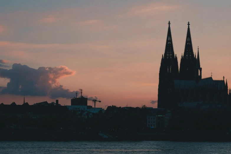 a cathedral and some buildings are behind the water