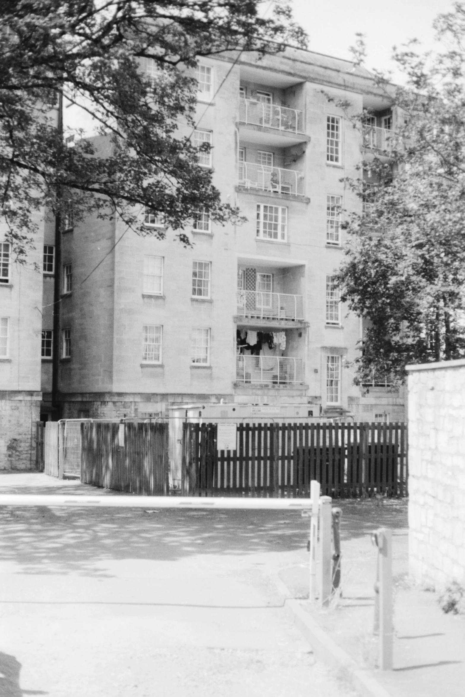 black and white image of an apartment building in a city