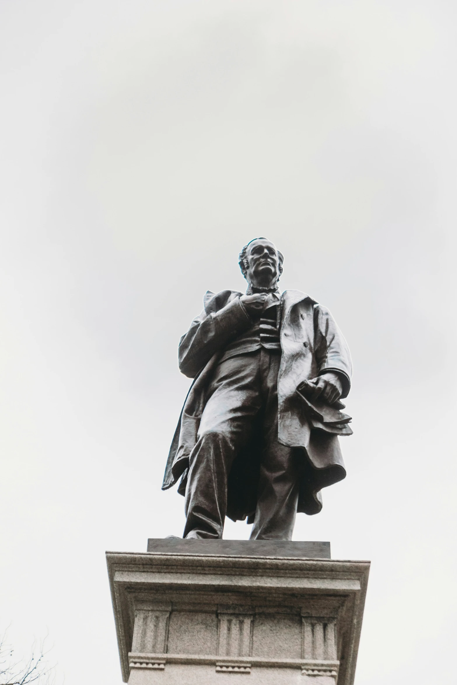 the statue is sitting high above the building