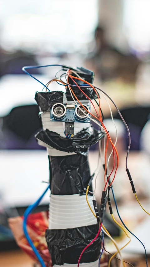 an image of a weird looking robot holding wires