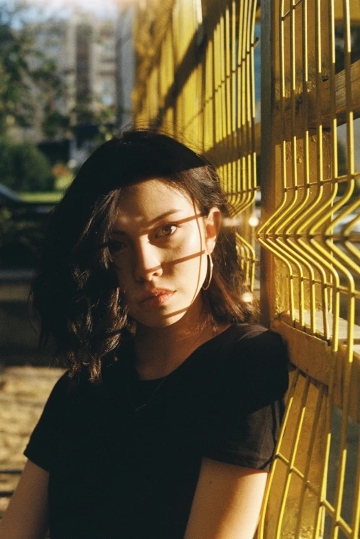 a woman poses next to a yellow structure