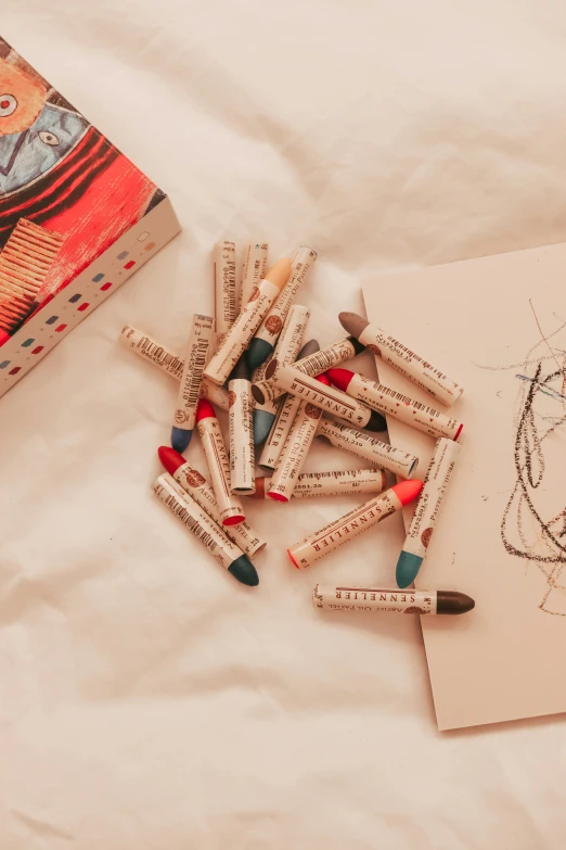 many pencils and some drawing pens sitting on a table