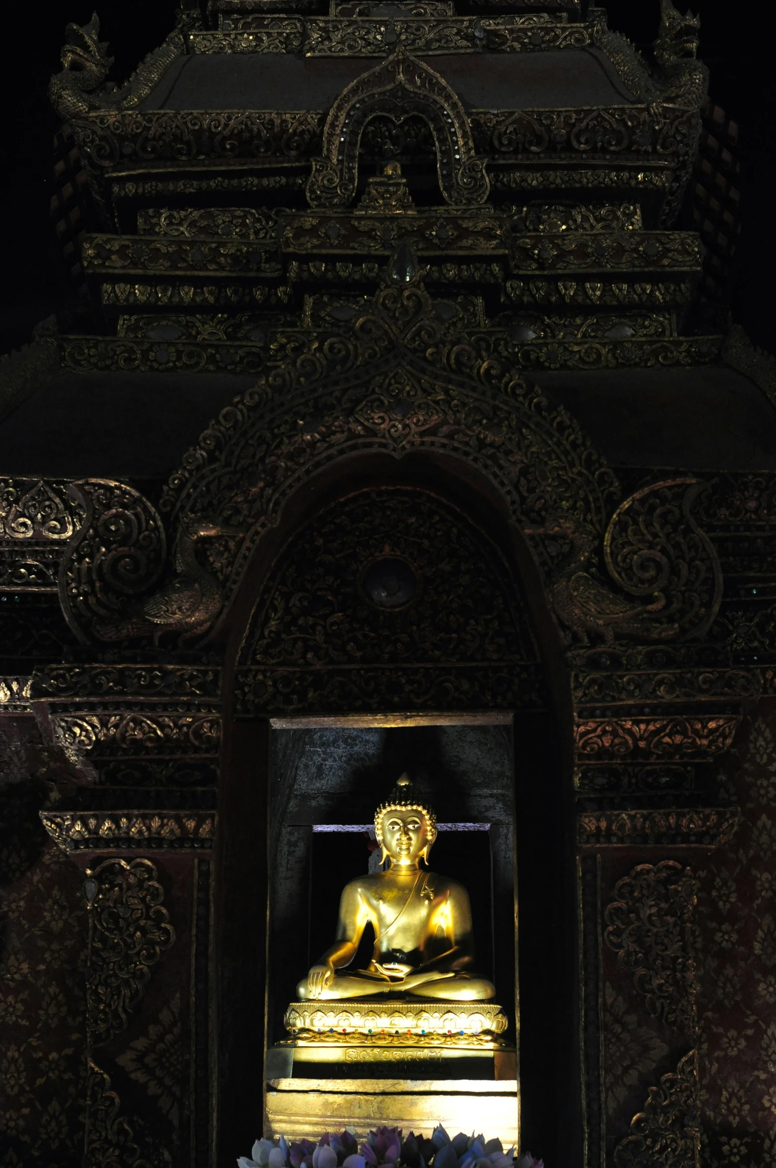 a gold statue of a person sitting on a bench