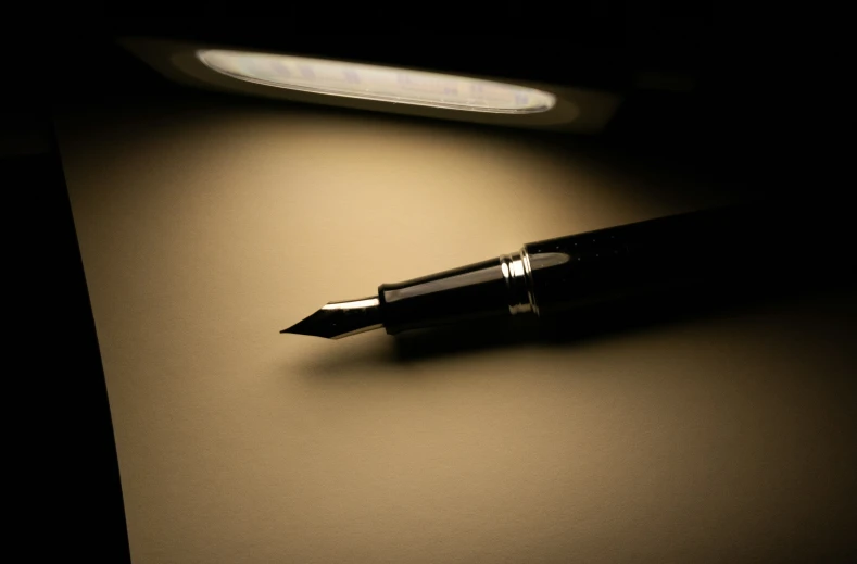 black and white pograph of a pen on a table