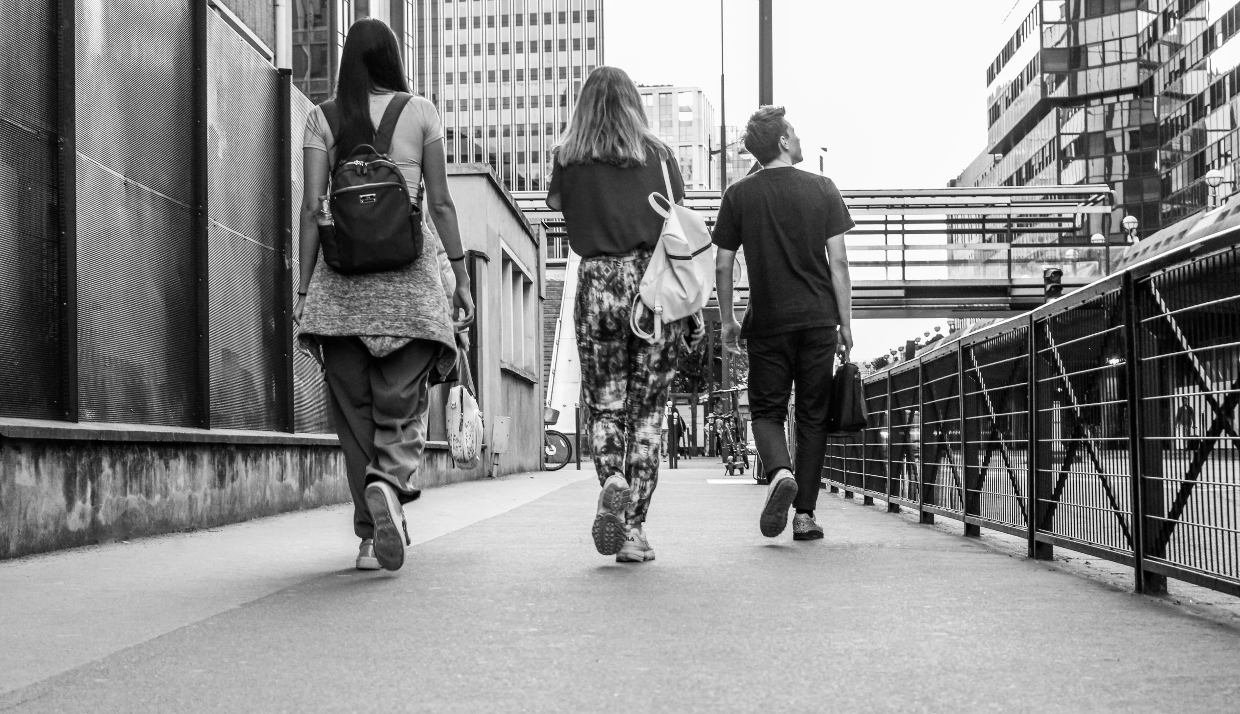 two people walking down an alley way while carrying luggage