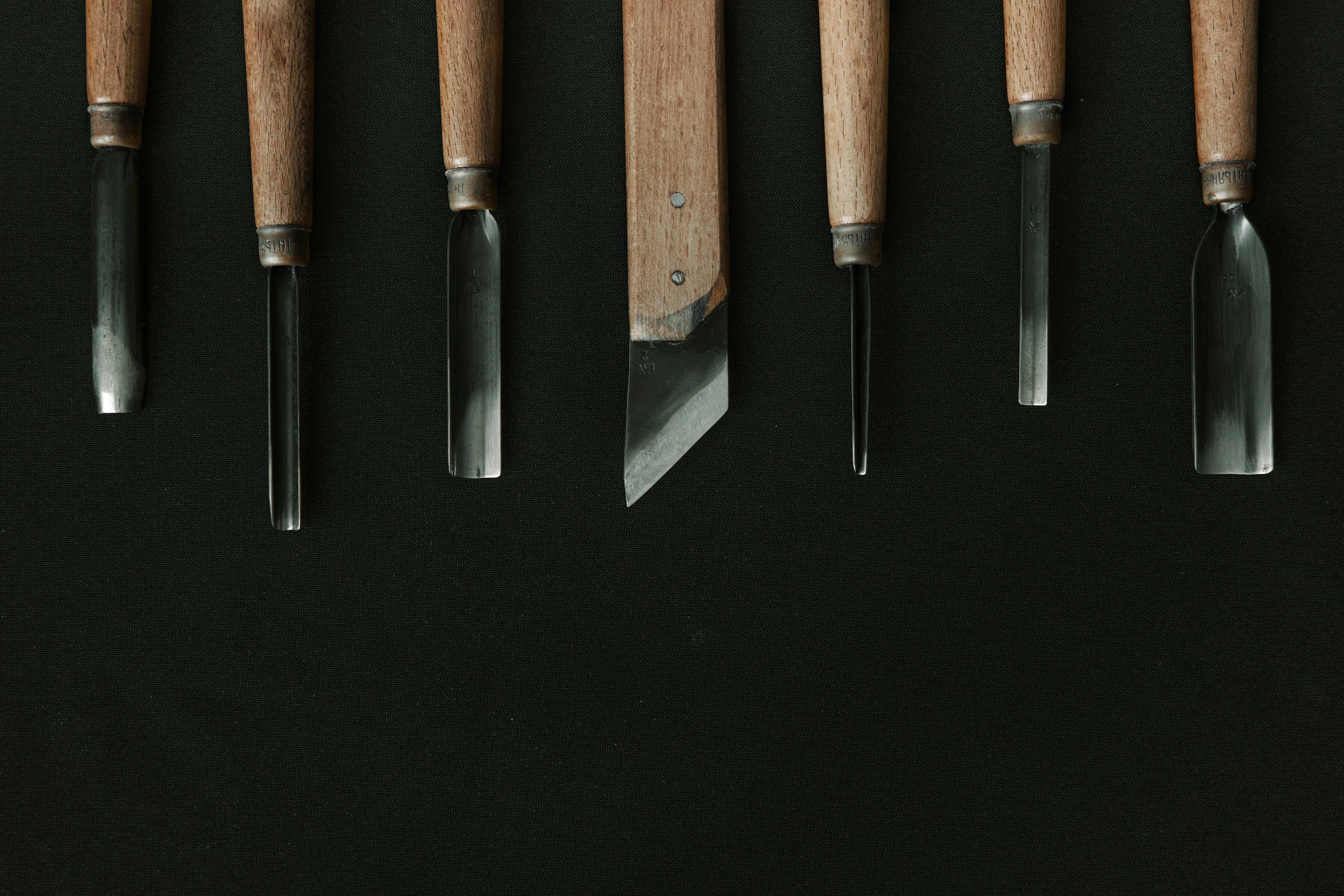 five wood handled knives hanging on each other